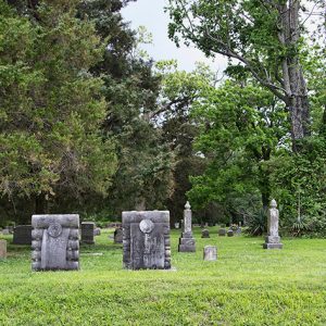 Gravestones and monuments under trees in cemetery