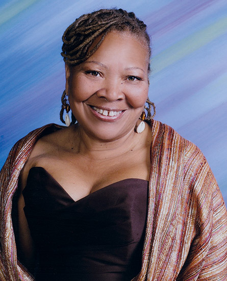 African-American woman smiling in sleeveless top and multicolored shawl