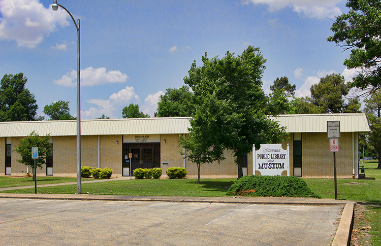 Single-story brick building with signs and parking lot