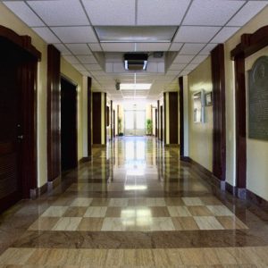Empty hallway with checkered floors and hanging ceiling