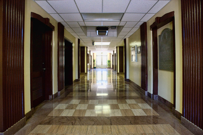 Empty hallway with checkered floors and hanging ceiling