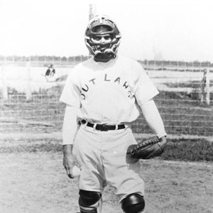 White man in catcher's uniform with glove and ball