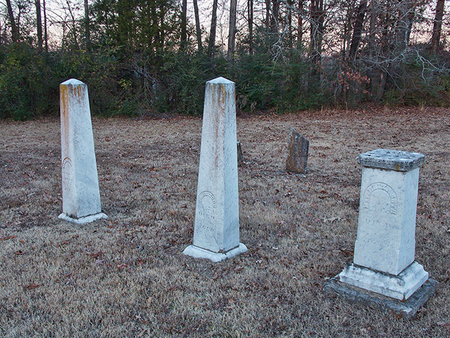 Obelisk shaped gravestones and pedestal shaped gravestone in cemetery