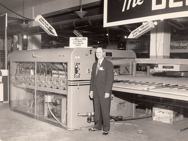 White man in suit and tie in factory with machinery