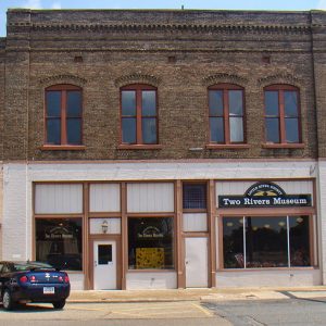Two-story brick building on street corner and signs
