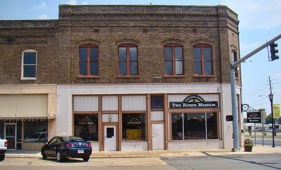 Two-story brick building on street corner and signs