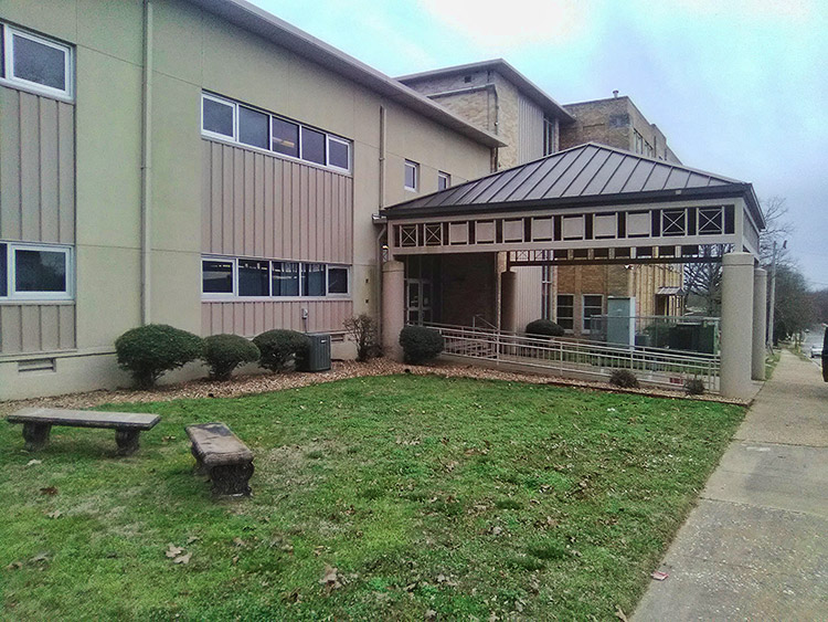 Multistory school building with covered entrance and wheelchair ramp