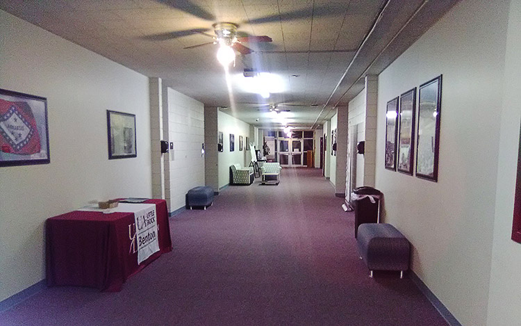 Interior hallway with furniture framed pictures on the walls and covered table on the left