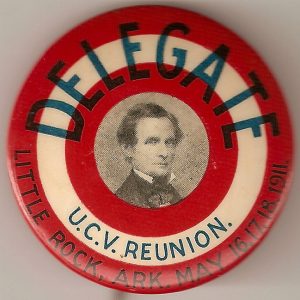 Red and white "delegate" badge with portrait of white man in suit in center and text below it