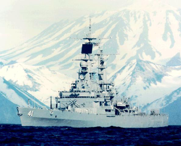 Naval ship at sea with mountain in the background