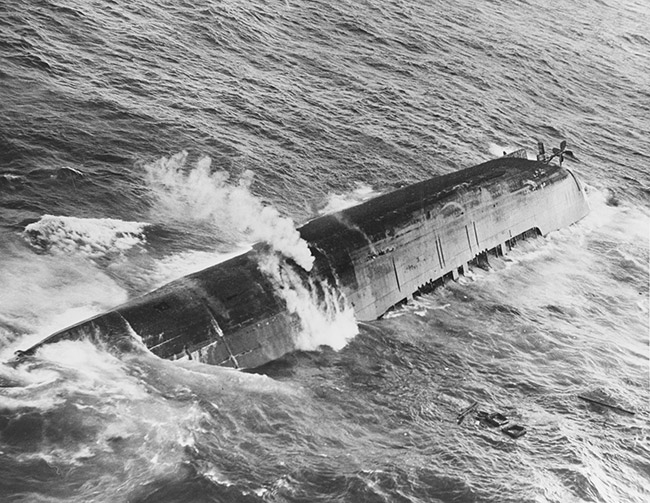 Capsized Naval ship sinking into the ocean