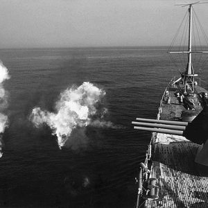 Navy warship firing its cannons at sea