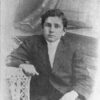 Young African-American boy in suit sitting in chair