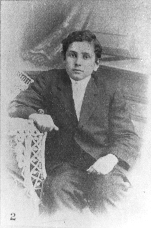 Young African-American boy in suit sitting in chair