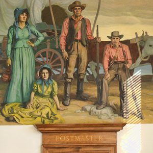 White men and women with covered wagon pulled by oxen in painting above "Postmaster" door