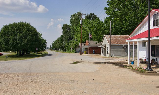 Single-story buildings and power lines on two-lane rural road
