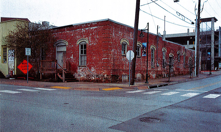 View from across the street of single-story brick building on street corner