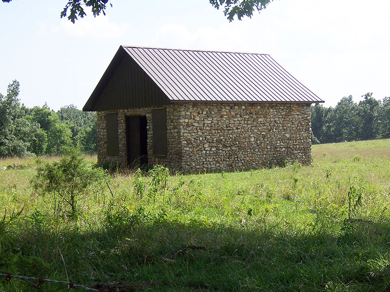 Brick building with new roof in field