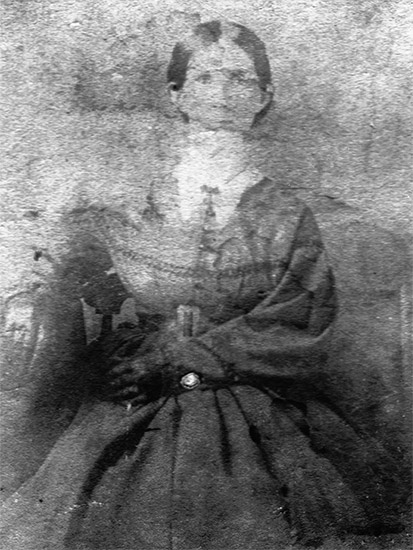 White woman in collared dress and gloves sitting in chair