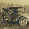 White men in military uniform posing with a car