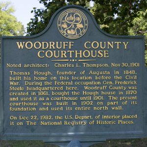 "Woodruff County Courthouse" historical marker sign with trees in background