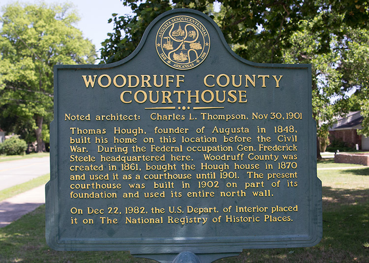 "Woodruff County Courthouse" historical marker sign with trees in background