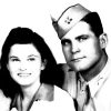 White woman with long hair smiling with white man in military uniform and cap