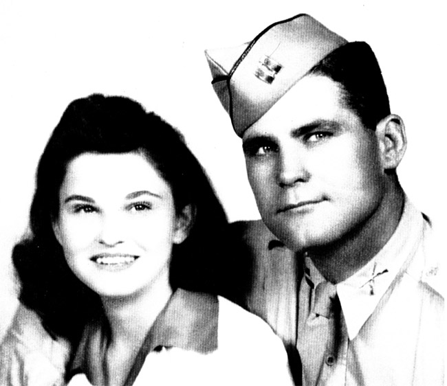 White woman with long hair smiling with white man in military uniform and cap