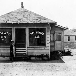 small wooden building with large windows reading, "Post Office U.S. West Memphis Ark."