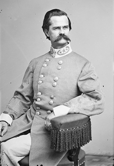 White man with mustache in gray military uniform sitting in chair