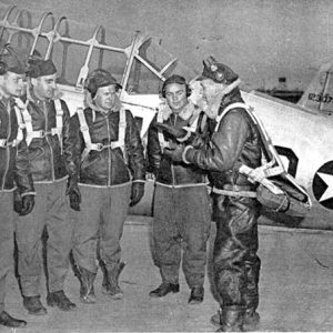 White men in pilot's uniforms with airplane
