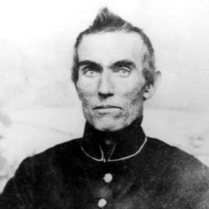 Old white man holding a revolver in military uniform
