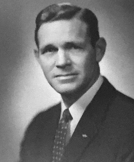 White man with side-parted hair in suit and tie
