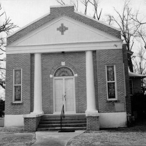 Front view of brick church building with arched doorway