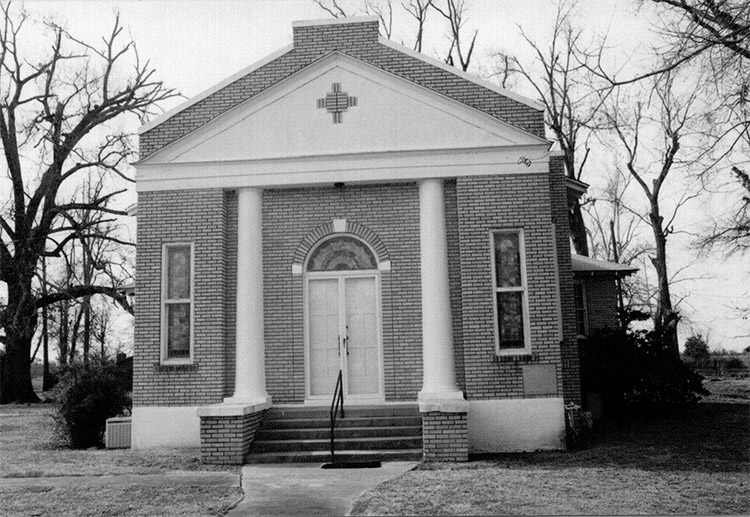 Front view of brick church building with arched doorway
