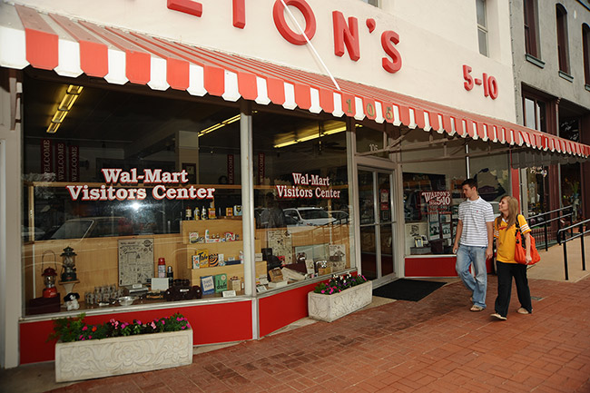 "Walton's" store with red and white awning and "Wal-Mart visitors center" on the windows