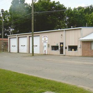 Fire department building with three garage bays and parking lot