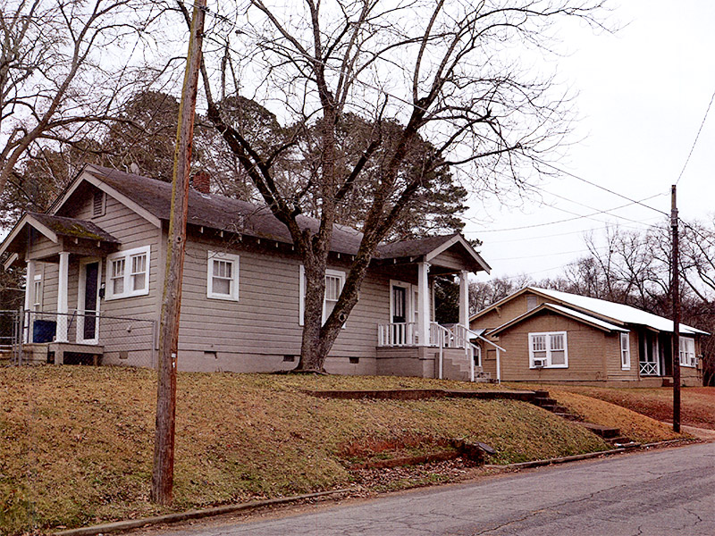 Houses with wood siding and covered porches on street