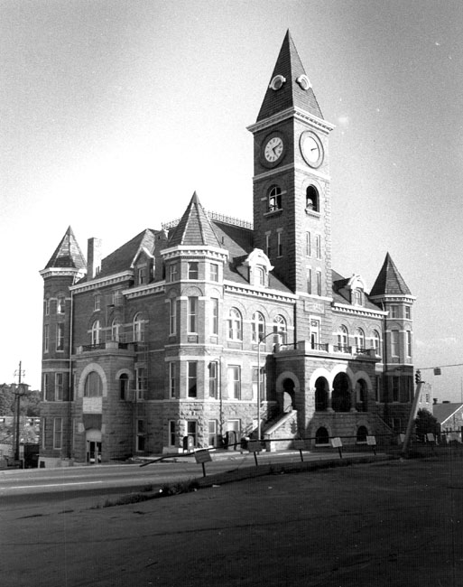 Three-story courthouse with bell and clock tower and arched entrances