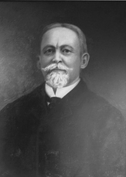 Older white man with mustache in a suit and tie
