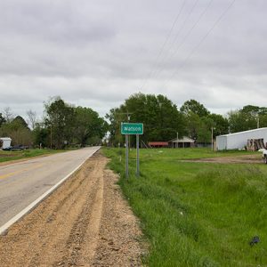 "Watson" road sign on two-lane highway