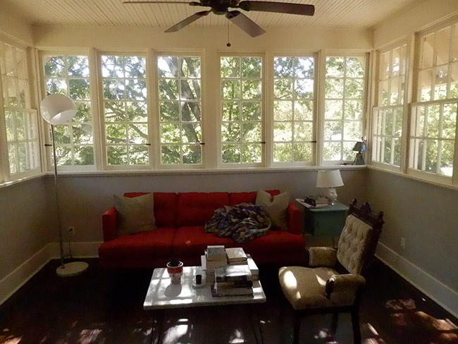 Interior of room with couch table and chair with windows overlooking trees