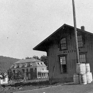 Railroad depot building and tracks with town building in background