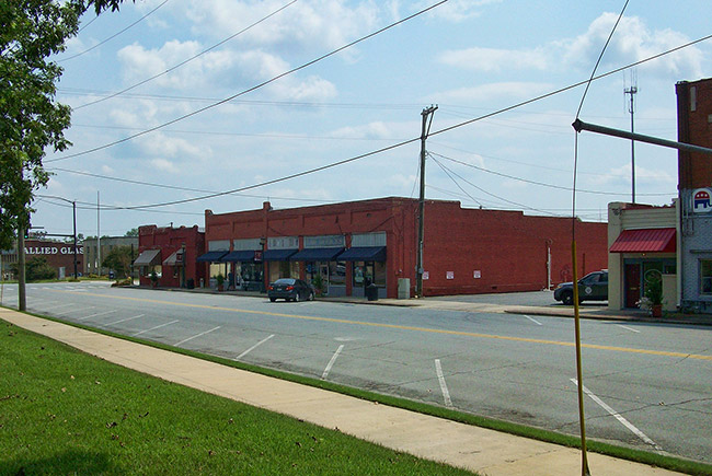 Brick storefront buildings on two-lane town street