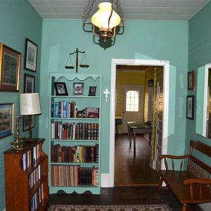 Interior of room with bookshelves and wooden bench under hanging light fixture