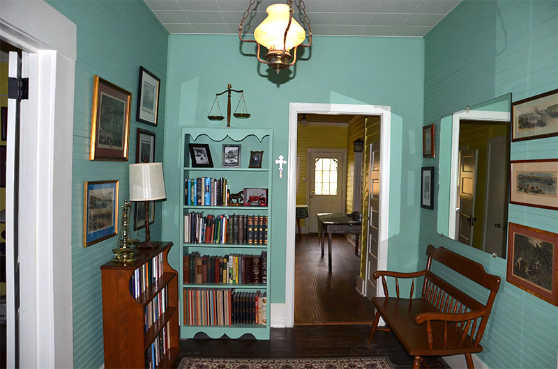 Interior of room with bookshelves and wooden bench under hanging light fixture