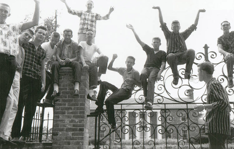 Group of young white men perched on governor's mansion gates