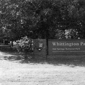 "Whittington Park Hot Springs National Park" sign with trees behind it on grass