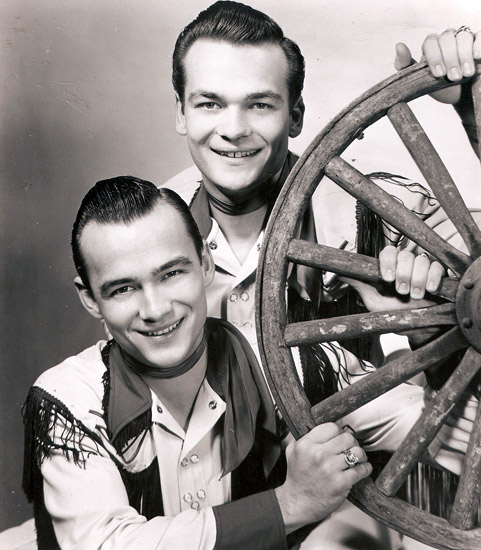 Young white men in western suits with wagon wheel