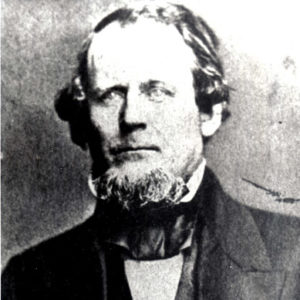 White man with beard in suit and white shirt